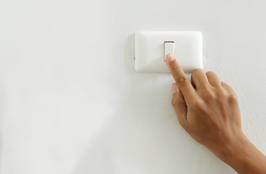 close-up of a finger pressing a light switch